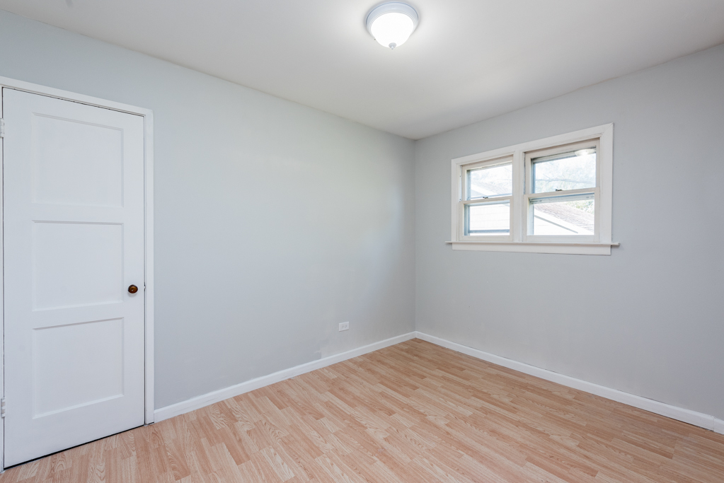 1636 Rice Street Waukegan, IL 60087 - Photo 12 of 26 an empty room with wooden floor and windows