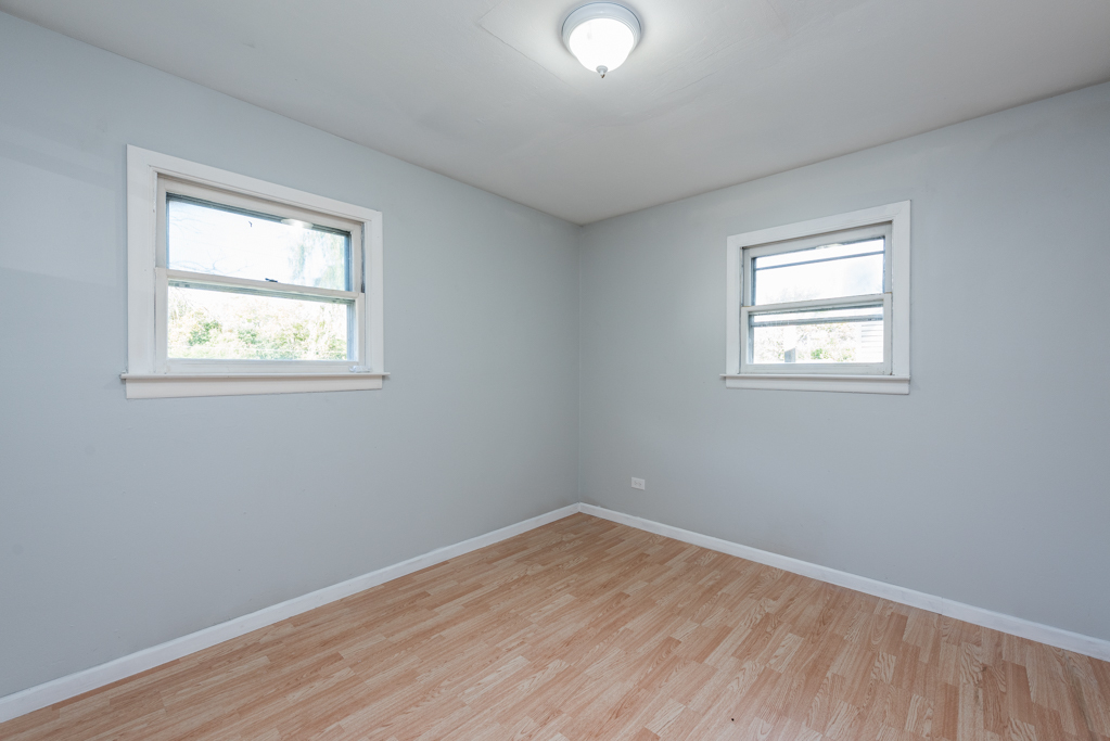 1636 Rice Street Waukegan, IL 60087 - Photo 16 of 26 an empty room with wooden floor and windows