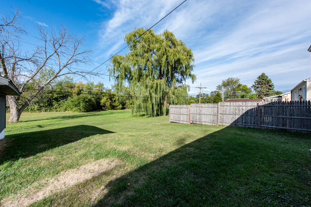1636 Rice Street Waukegan, IL 60087 - Photo 22 of 26 a backyard of a house with lots of green space and trees all around