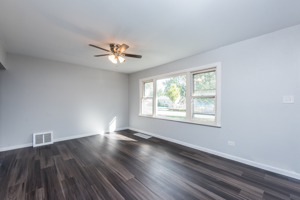 1636 Rice Street Waukegan, IL 60087 - Photo 7 of 26 wooden floor in an empty room with a window
