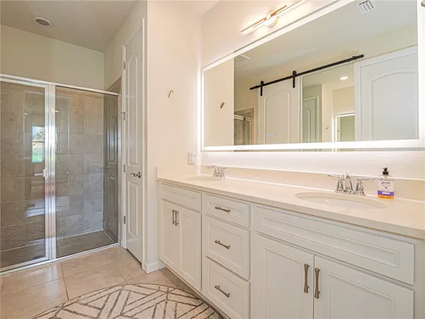 a spacious bathroom with a shower sink and mirror