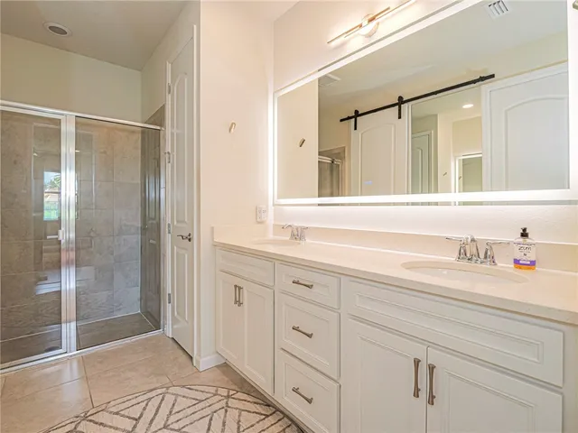 a spacious bathroom with a shower sink and mirror