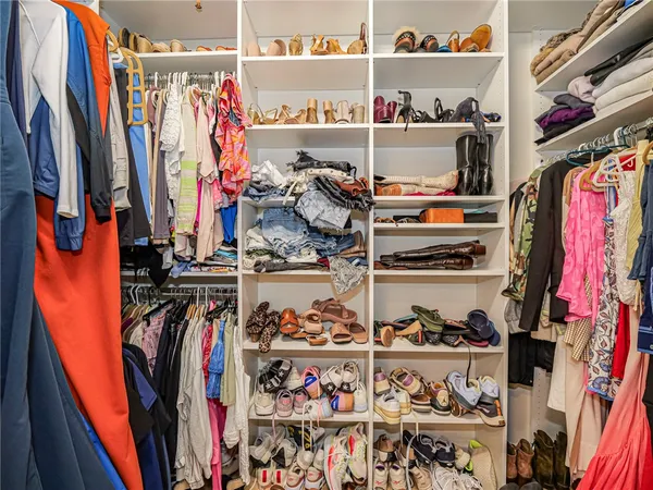 a view of walk in closet with clothes