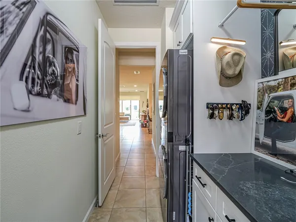 a hallway with painting on the wall and a granite counter tops