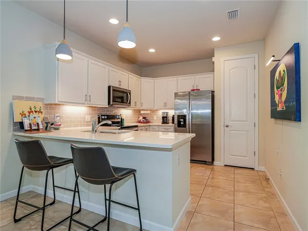 a kitchen with stainless steel appliances granite countertop a refrigerator and a stove top oven