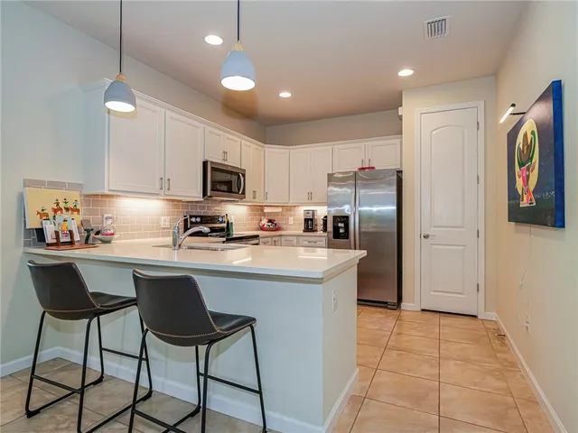 a kitchen with stainless steel appliances granite countertop a refrigerator and a stove top oven