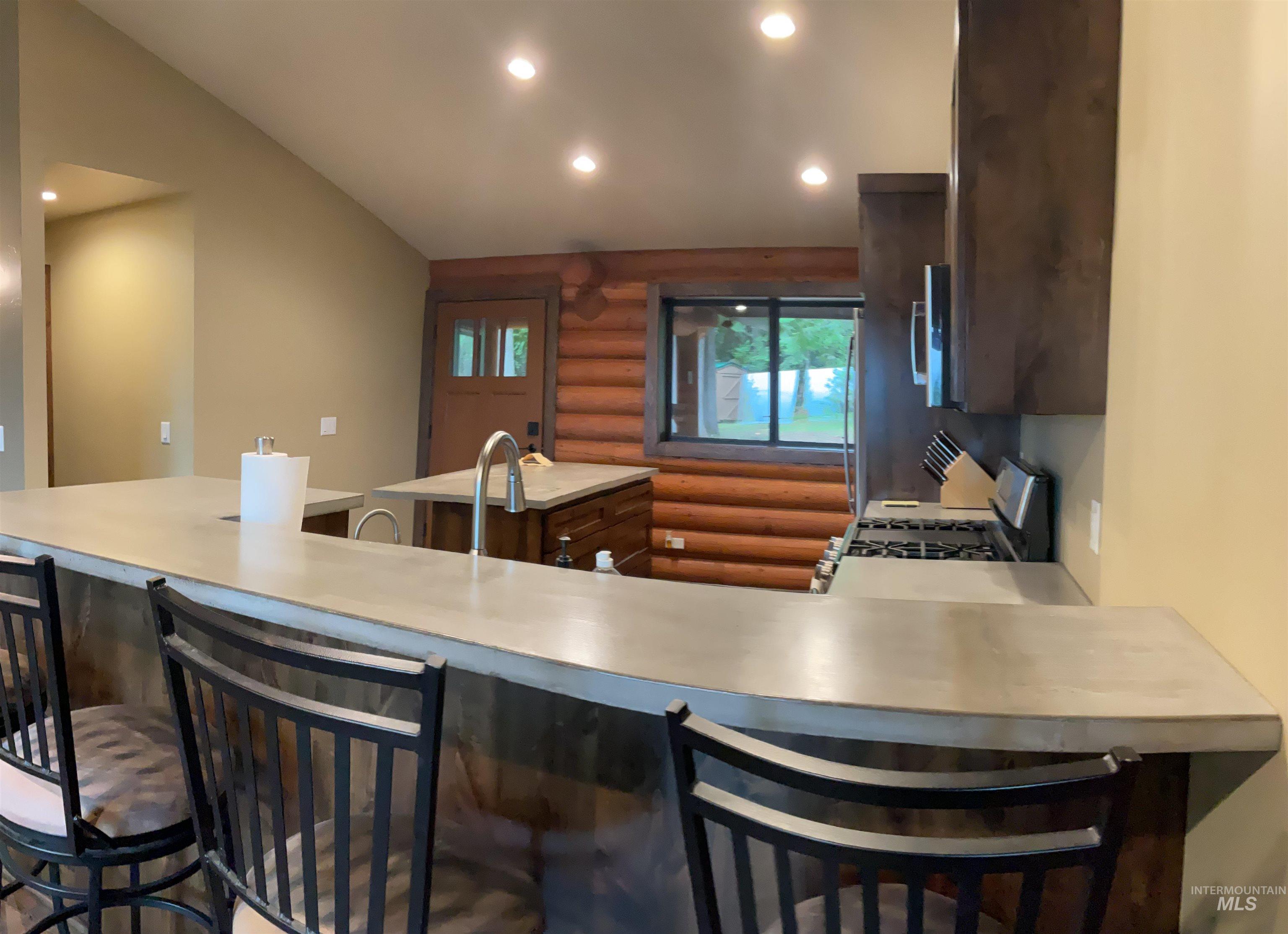 6125 Freeman Creek Road Lenore, ID 83541 - Photo 10 of 44 Contemporary kitchen featuring light-toned countertops, a gas range, dark wood-finish cabinetry, and recessed lighting