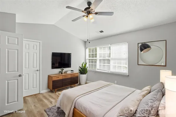 a bedroom with a large bed and a chandelier