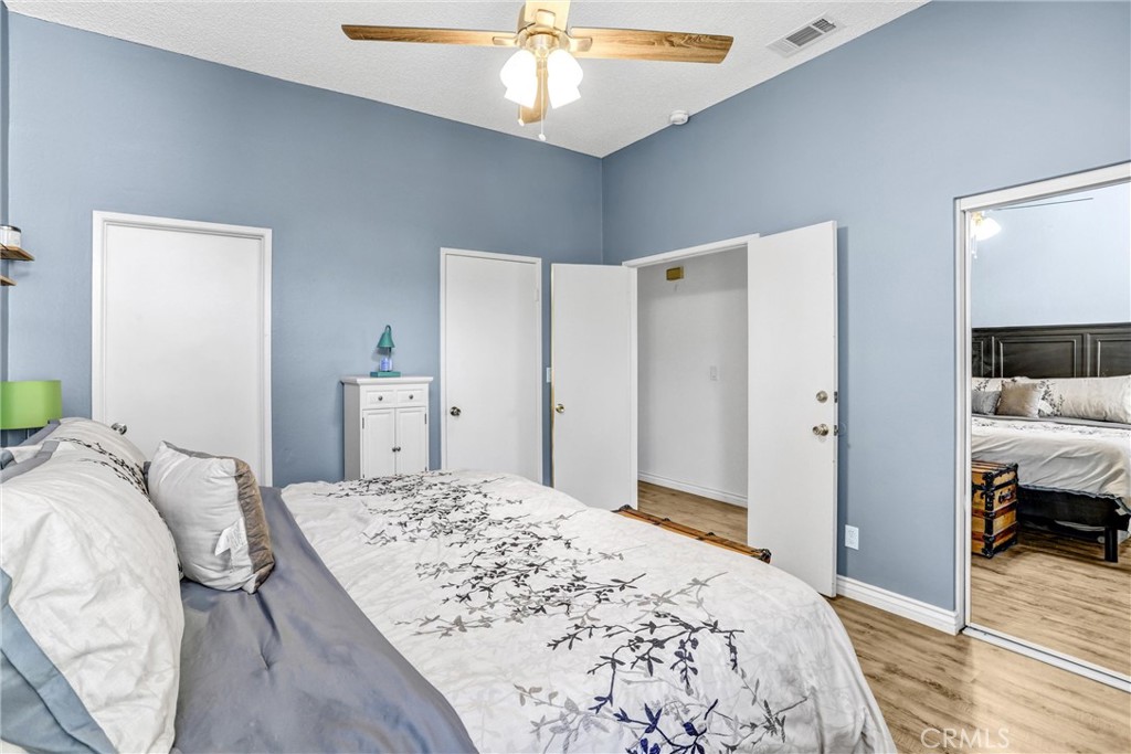 14519 El Contento Avenue Fontana, CA 92337 - Photo 14 of 30 a bedroom with a bed and a chandelier