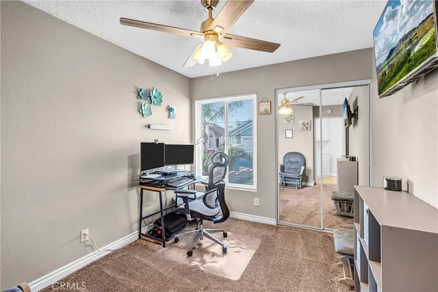 a view of a workspace with furniture and a window