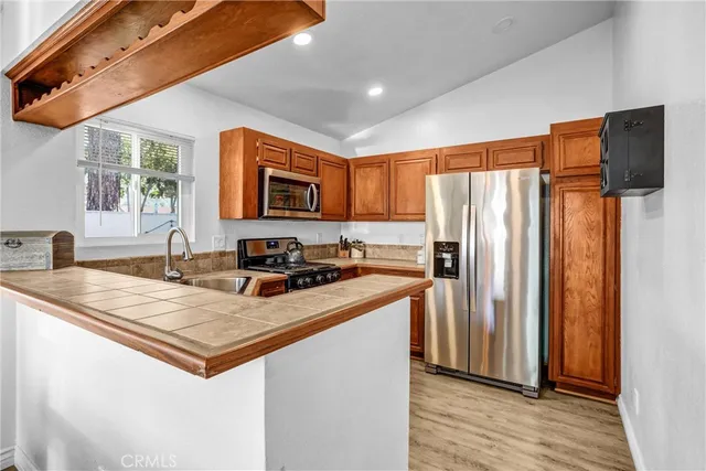 a kitchen with stainless steel appliances granite countertop a refrigerator a stove a sink and a microwave