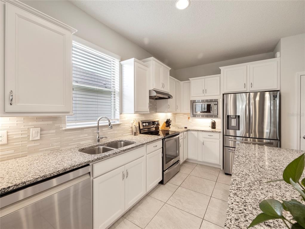 7807 Southwest 97th Circle Ocala, FL 34481 - Photo 12 of 50 a kitchen with granite countertop a sink stainless steel appliances and cabinets