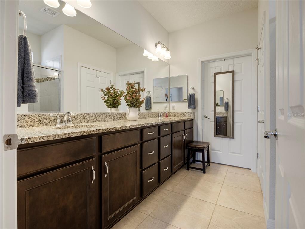 7807 Southwest 97th Circle Ocala, FL 34481 - Photo 26 of 50 a bathroom with a granite countertop sink a mirror and a