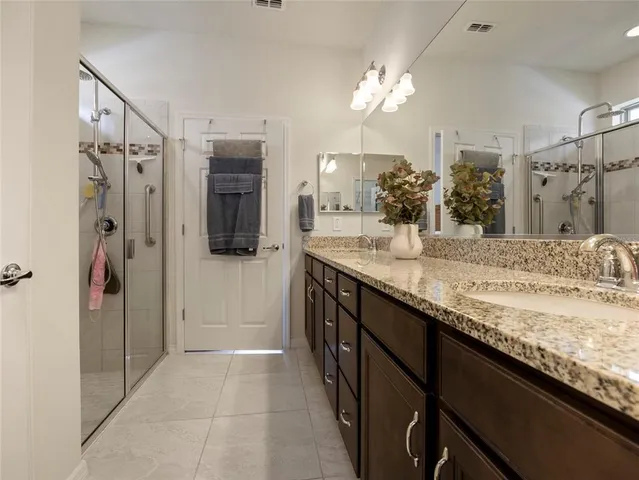 a bathroom with a granite countertop sink a large mirror and a shower
