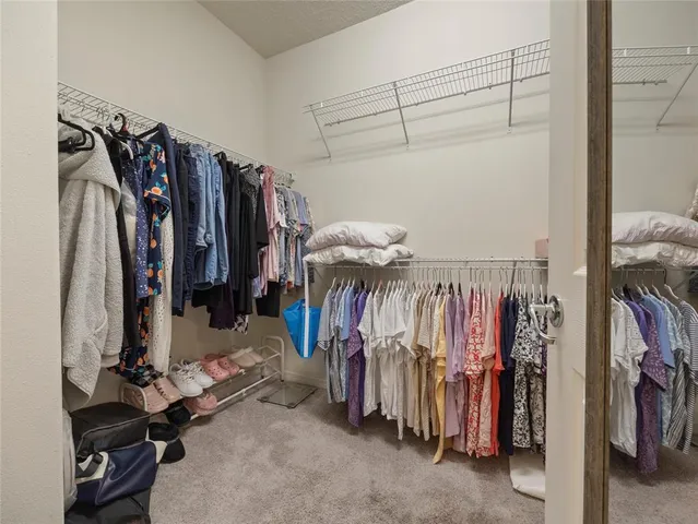 a view of walk in closet with clothes