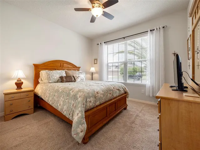 a bedroom with a bed flat screen tv and a large window