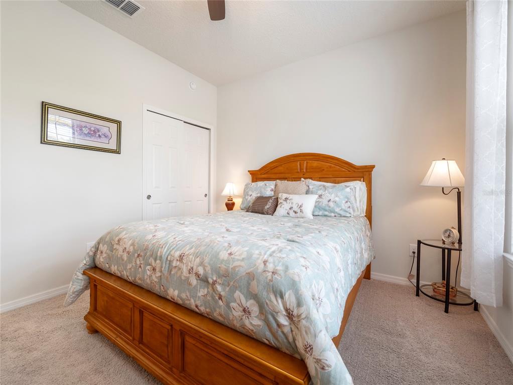 7807 Southwest 97th Circle Ocala, FL 34481 - Photo 35 of 50 a bedroom with a bed and a lamp on table