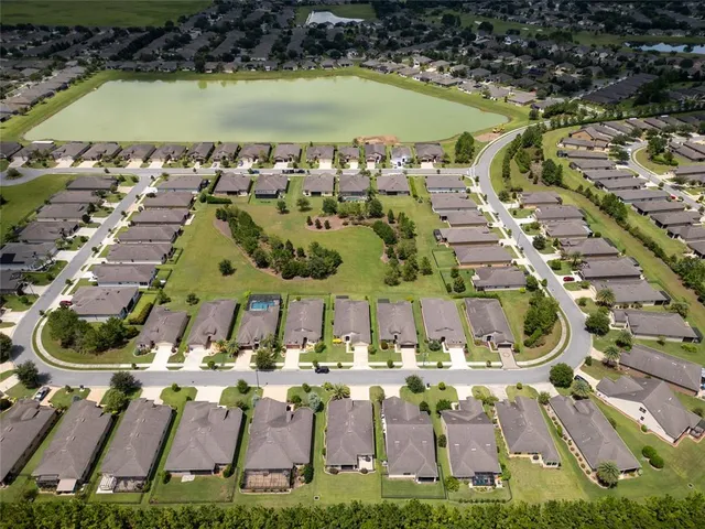 an aerial view of a house with a garden and lake view