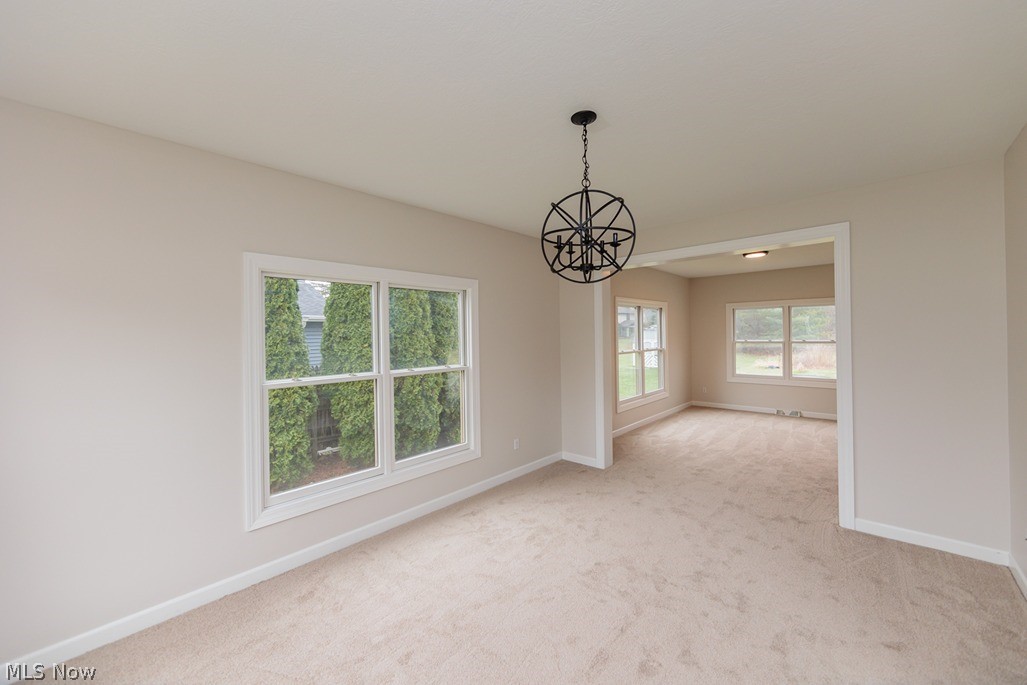6947 Som Center Road Solon, OH 44139 - Photo 14 of 50 Empty room featuring light colored carpet and a notable chandelier