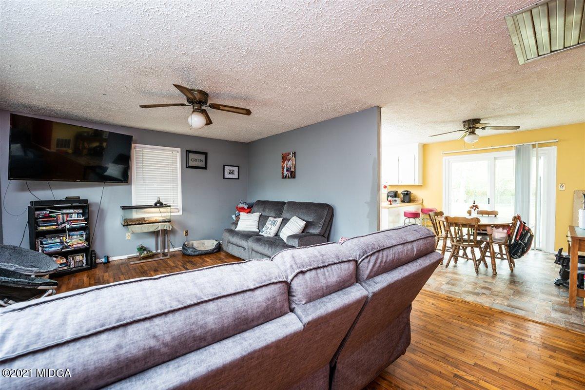 2805 South Estates Road Macon, GA 31216 - Photo 3 of 17 a living room with furniture a flat screen tv and kitchen view
