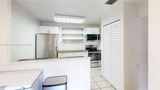 a view of a kitchen with cabinets and washer dryer