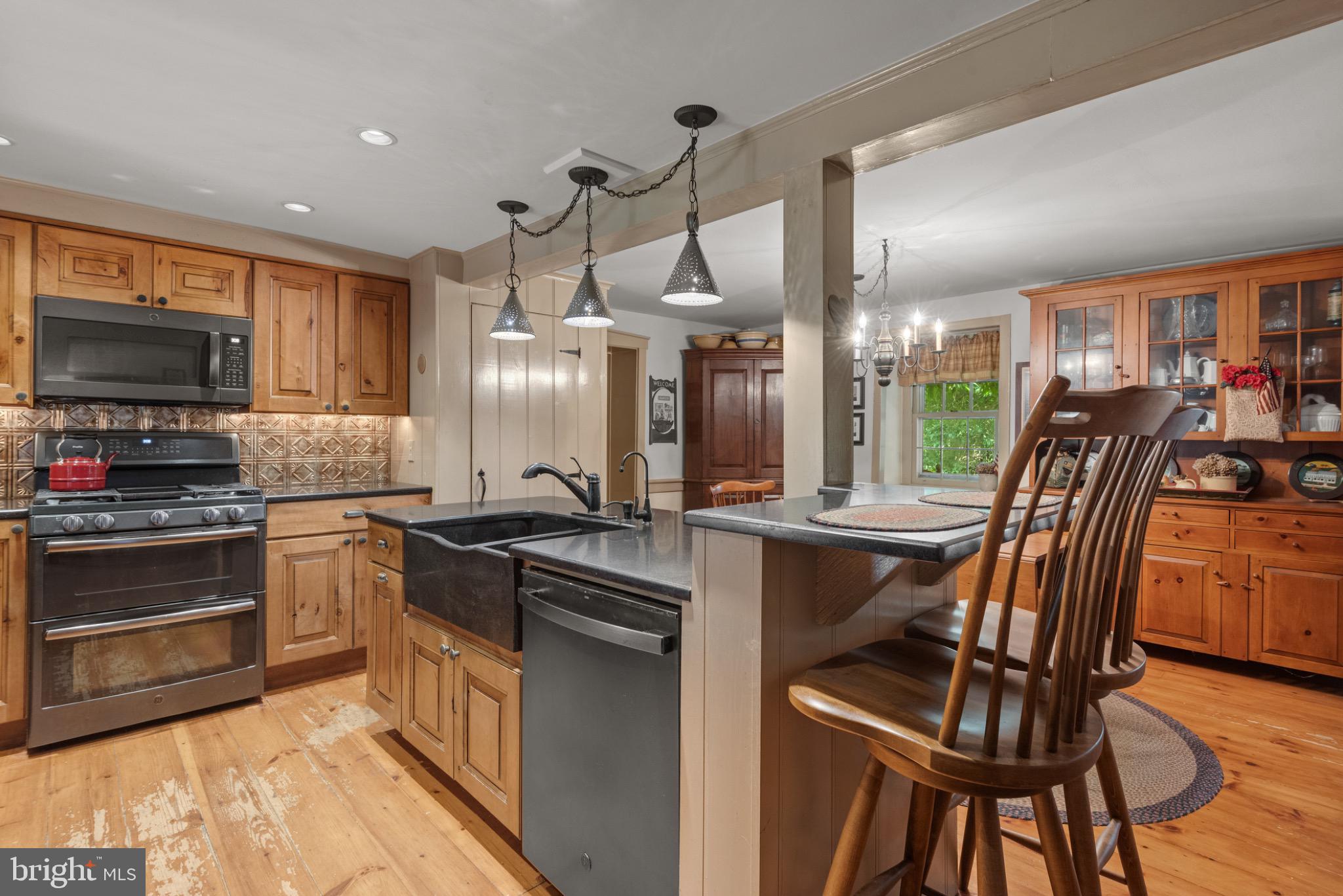 1592 White Oak Road Strasburg, PA 17579 - Photo 12 of 68 a kitchen with stainless steel appliances granite countertop a stove top oven a sink dishwasher a dining table and chairs with wooden floor