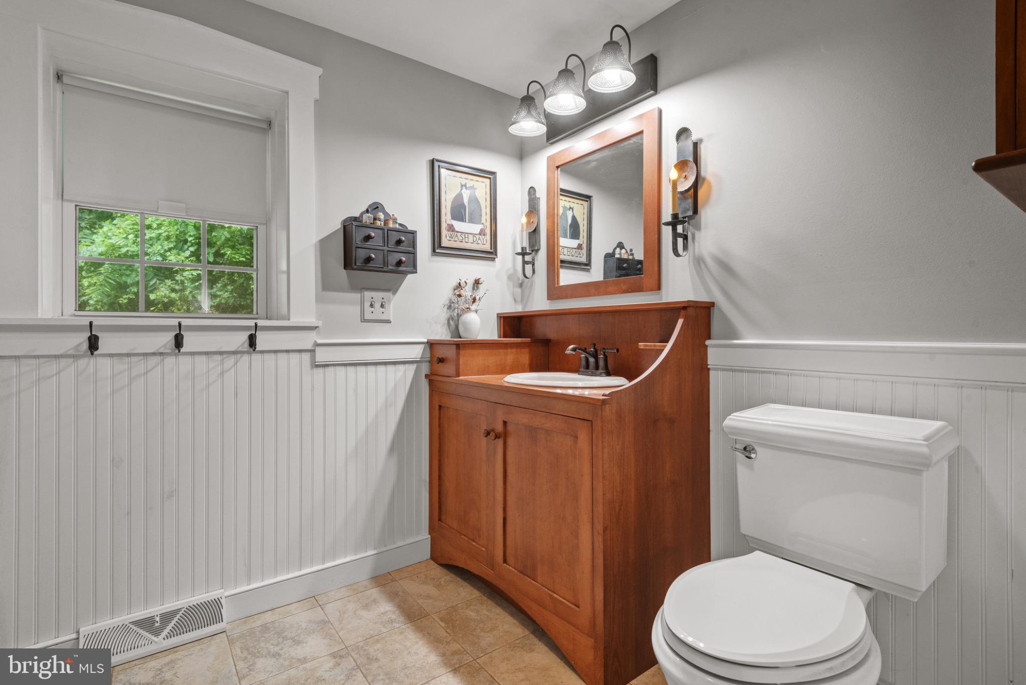 1592 White Oak Road Strasburg, PA 17579 - Photo 31 of 68 a bathroom with a toilet a sink a mirror a window and vanity