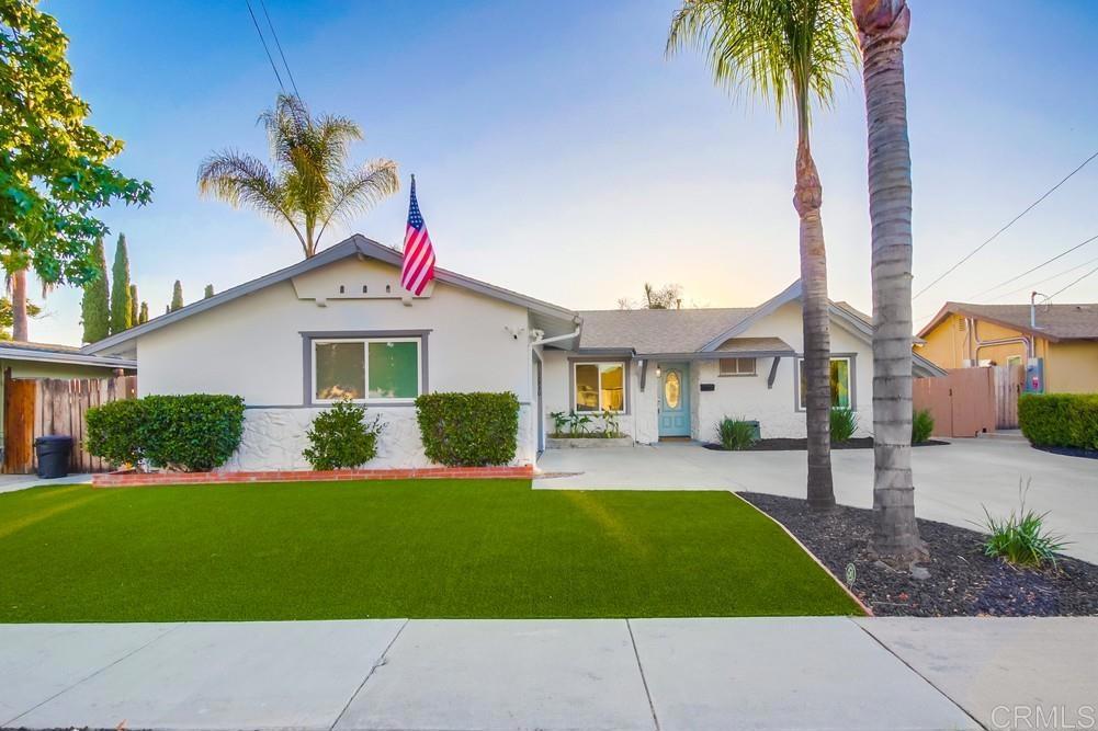 a front view of a house with a yard and potted plants