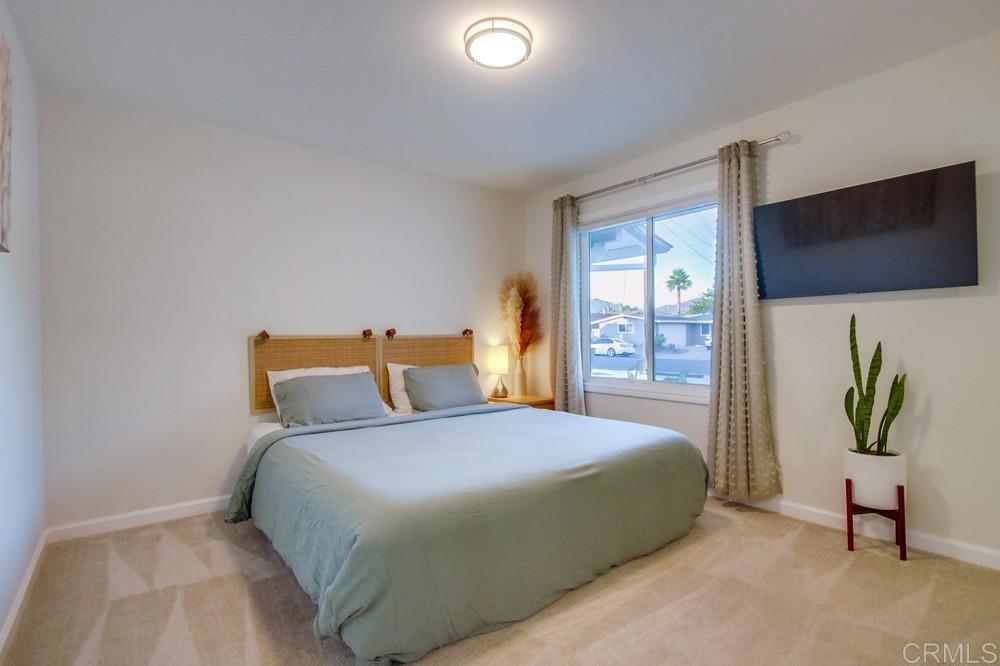 12930 Morene Street Poway, CA 92064 - Photo 23 of 26 a bedroom with a bed table and a flat tv screen