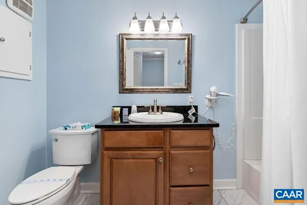 a bathroom with a sink vanity mirror and toilet
