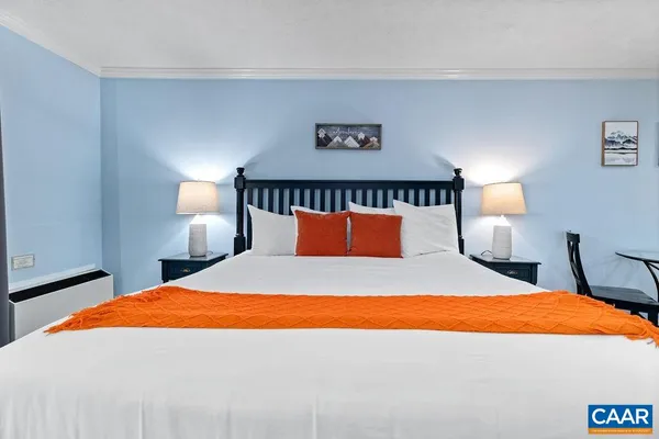 a bed sitting in a bedroom with a lamp and a lamp