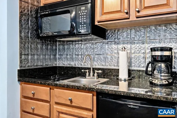 a kitchen with granite countertop a sink and a microwave