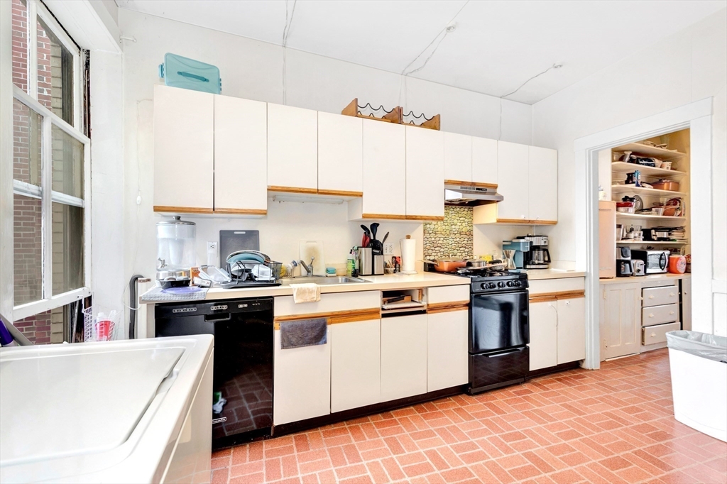 106 Strathmore Road Boston, MA 02135 - Photo 14 of 30 a kitchen with stainless steel appliances and white cabinets