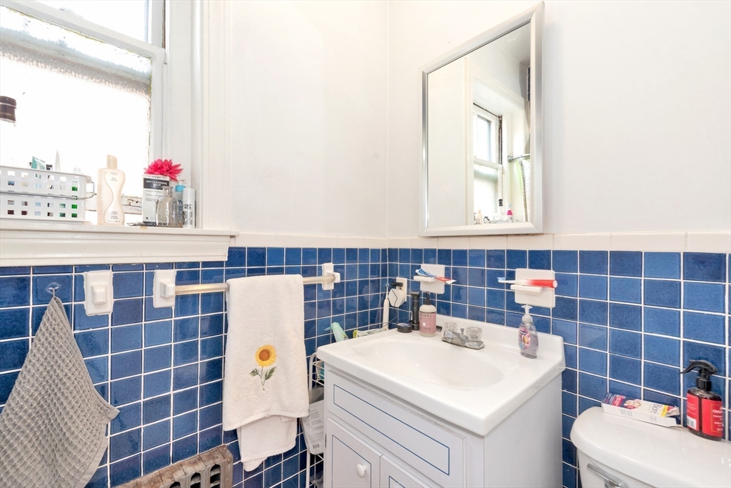 106 Strathmore Road Boston, MA 02135 - Photo 15 of 30 a bathroom with a sink a toilet and a mirror
