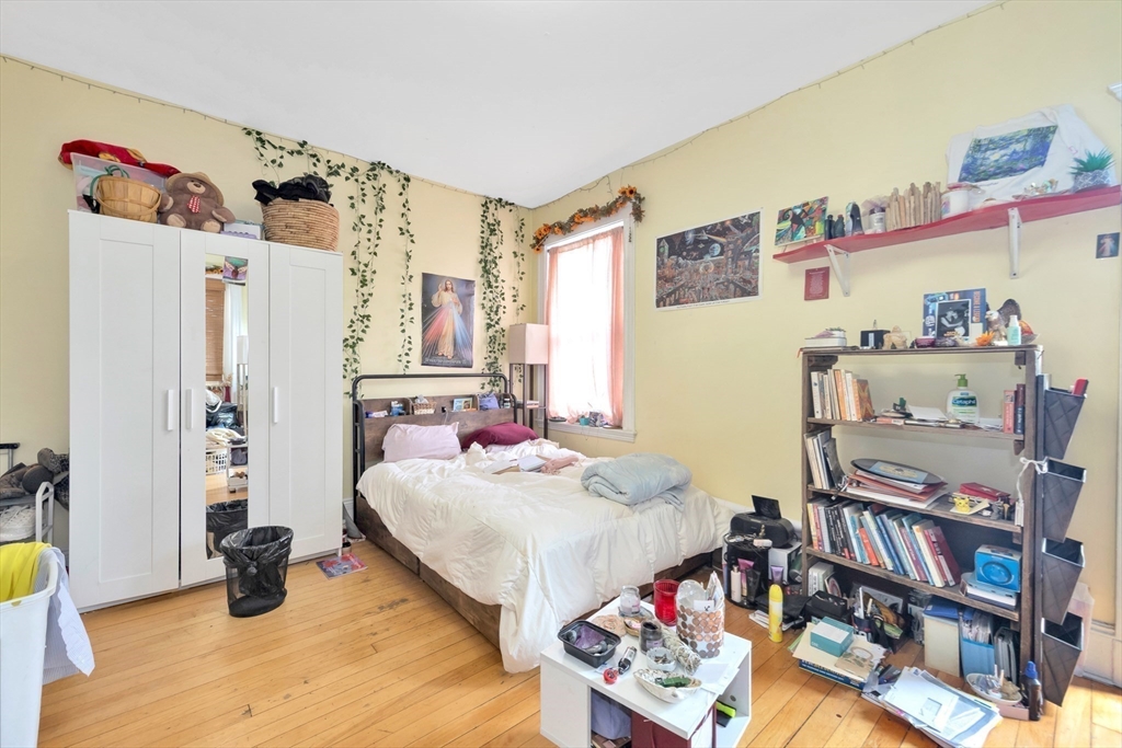 106 Strathmore Road Boston, MA 02135 - Photo 18 of 30 a bedroom with a bed and a book shelf