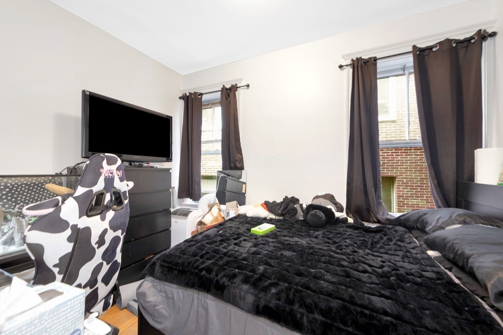 106 Strathmore Road Boston, MA 02135 - Photo 24 of 30 a large bedroom with a bed and flat screen tv
