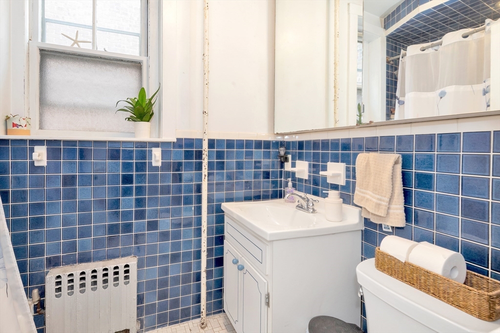 106 Strathmore Road Boston, MA 02135 - Photo 25 of 30 a bathroom with a sink a toilet and a mirror