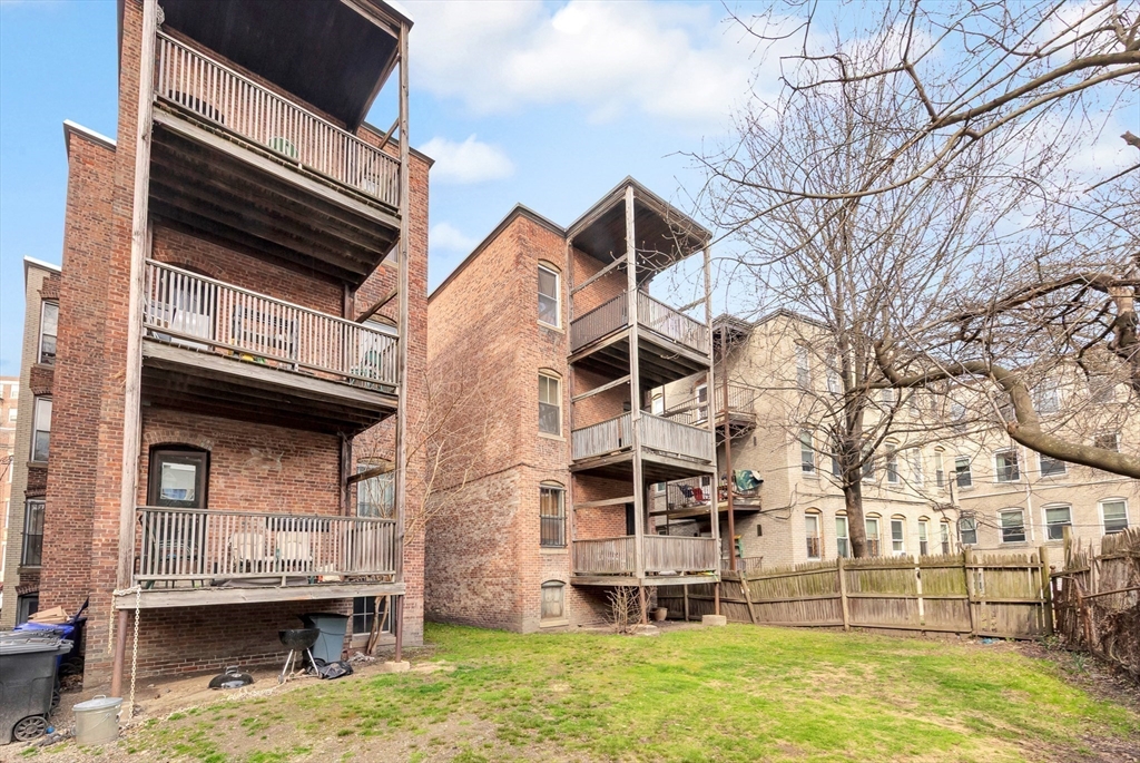 106 Strathmore Road Boston, MA 02135 - Photo 28 of 30 a backyard of a house with wooden fence and large trees