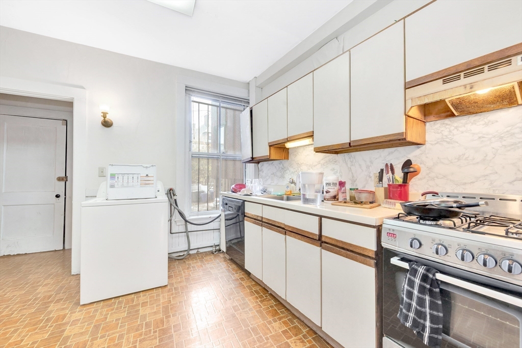 106 Strathmore Road Boston, MA 02135 - Photo 5 of 30 a kitchen with stainless steel appliances a stove a sink and a refrigerator