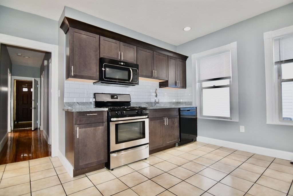 a kitchen with stainless steel appliances granite countertop a refrigerator and a stove top oven