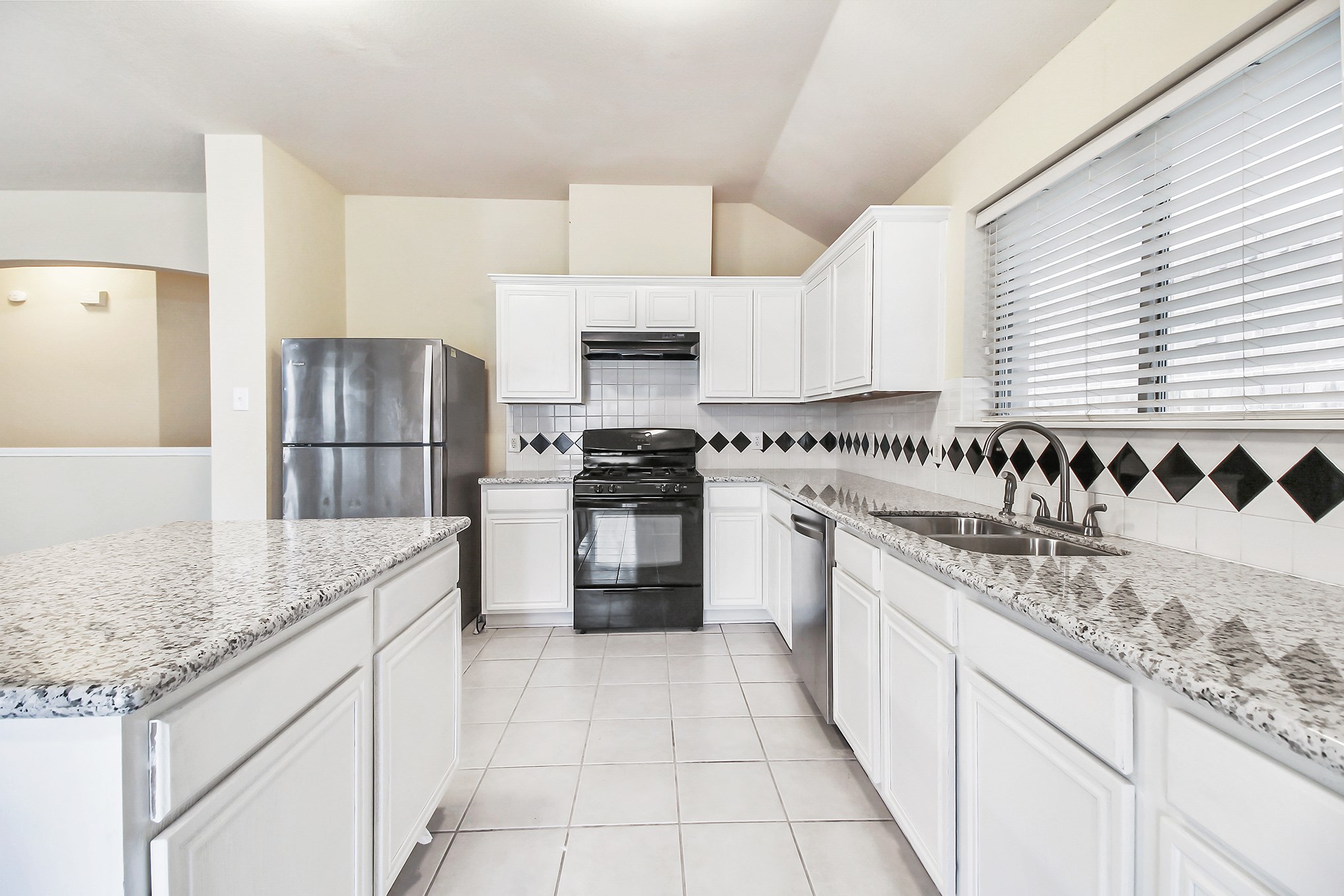 1814 Parkfair Court Katy, TX 77450 - Photo 16 of 36 Island Kitchen has the extra draws and cabinets for quick easy reach. Tile flooring, large double sink, colors all blend well with the white cabinetry plus plenty of natural light.