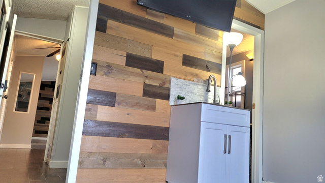 1525 South 400 East, Unit 63 Springville, UT 84663 - Photo 11 of 36 Hallway featuring wood walls, a textured ceiling, and wood finished floors leading to Primary bedroom
