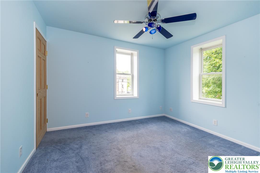 1815 Leithsville Road Hellertown, PA 18055 - Photo 11 of 38 A cheerful bedroom with two windows and a ceiling fan, offering a tranquil retreat.
