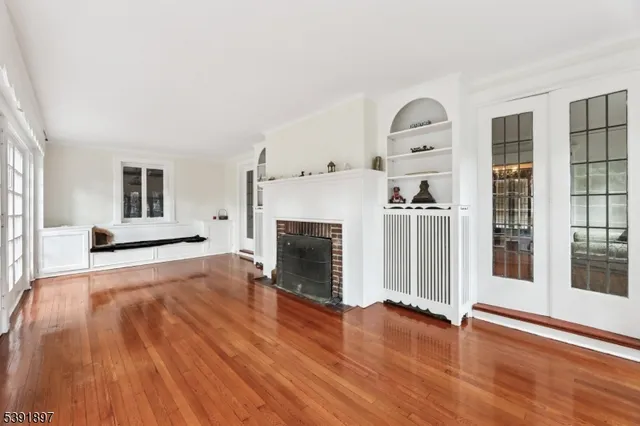 a view of a livingroom with wooden floor and a fireplace