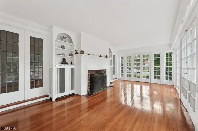 wooden floor fireplace and windows in an empty room