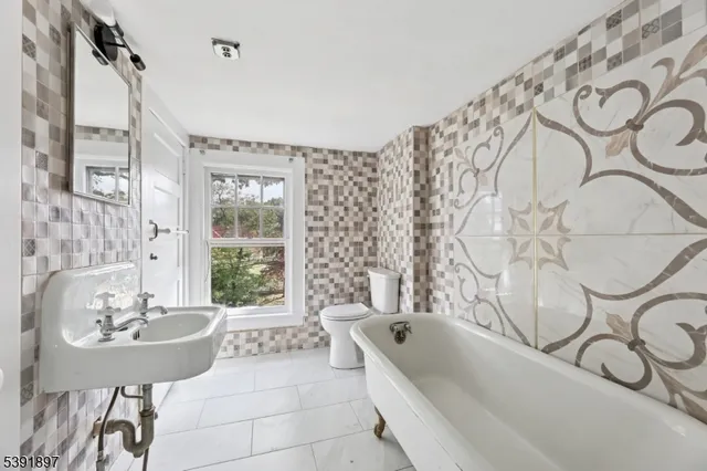 a bathroom with a bathtub sink and mirror