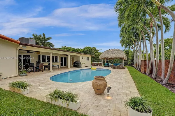 a front view of house and yard with swimming pool and furniture