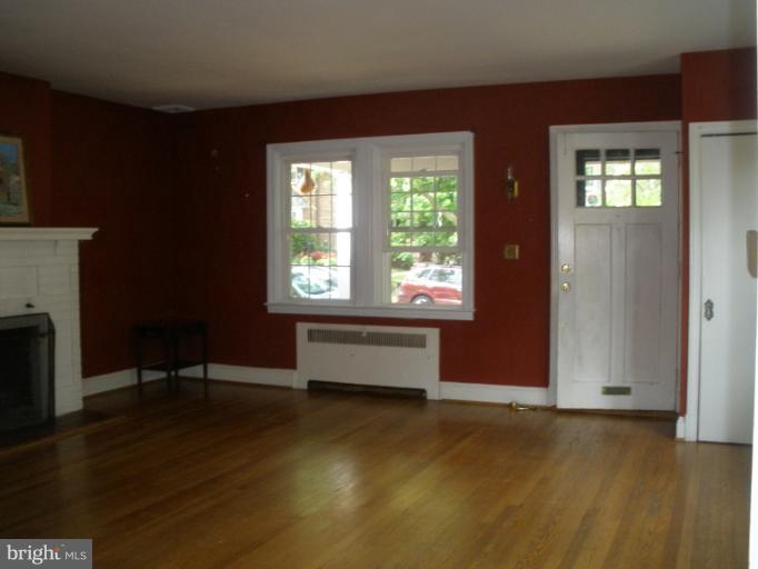 321 Dunkirk Road Baltimore, MD 21212 - Photo 26 of 30 an empty room with windows a fireplace and wooden floor