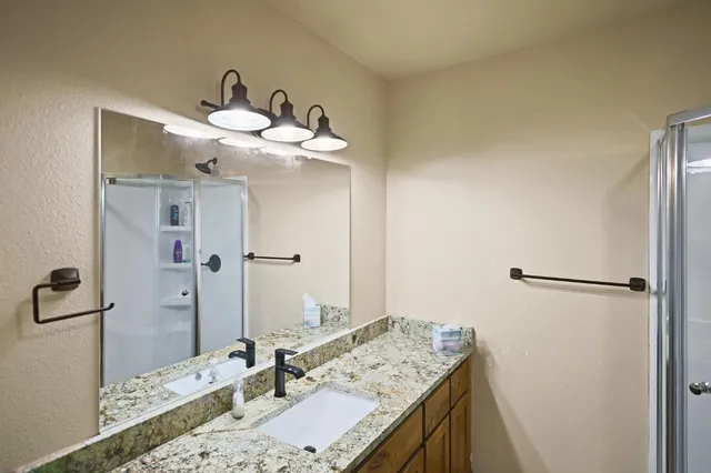 a bathroom with a granite countertop sink and a mirror