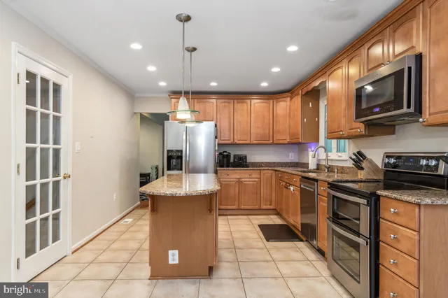 a kitchen with stainless steel appliances granite countertop a refrigerator stove microwave and sink